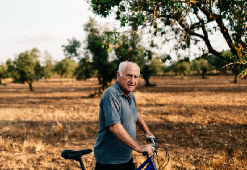 elderly man next to adult tricycle