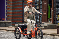 an adult gentleman riding a folding electric tricycle through an urban area