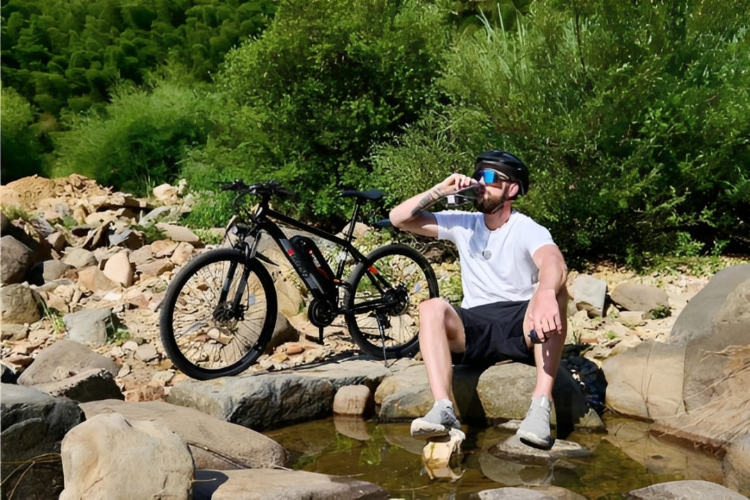 a man resting in the mountains with his electric mountian bike parked beside him