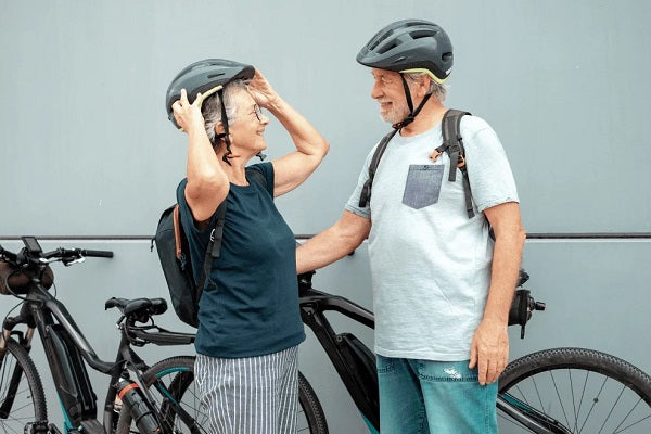 elderly couple wearing bike helmets for adults